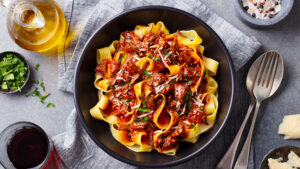 A bowl of pasta with meat and sauce.